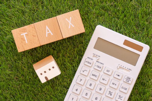 税金｜「TAX」と書かれた積み木と電卓と小銭